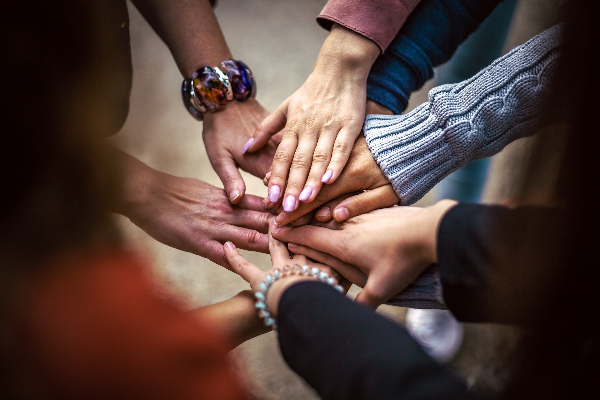 People placing hands on top of one another's